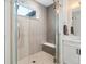 Elegant walk-in shower featuring glass doors, tile surround, and a built-in bench at 5469 S Curtice St # E, Littleton, CO 80120