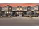 Modern townhomes featuring brick facade, blue doors, and manicured landscaping at 5469 S Curtice St # E, Littleton, CO 80120