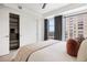 Bright bedroom featuring closet with storage and city views from the window at 1750 Wewatta St # 1304, Denver, CO 80202