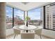 Chic dining area with city views framed by large windows and designer furnishings at 1750 Wewatta St # 1304, Denver, CO 80202