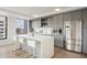 Modern kitchen with grey cabinets, stainless steel appliances, and an island with a white countertop and barstool seating at 1750 Wewatta St # 1304, Denver, CO 80202