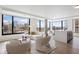 Bright open-concept living room featuring floor-to-ceiling windows with stunning city views and modern white furniture at 1750 Wewatta St # 1304, Denver, CO 80202