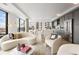 Bright living space with modern kitchen, elegant white furniture, and large windows showcasing vibrant city views at 1750 Wewatta St # 1304, Denver, CO 80202