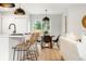 Open floor plan combining kitchen island seating with a casual dining area and backyard access at 3061 S Glencoe St, Denver, CO 80222