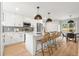 White kitchen featuring island with pendant lights and seating; flows to dining at 3061 S Glencoe St, Denver, CO 80222