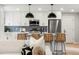 Modern kitchen featuring white cabinetry, a gray backsplash, and wicker counter stools at 3061 S Glencoe St, Denver, CO 80222