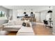 Bright open-concept living room with a modern kitchen and sleek hardwood flooring at 3061 S Glencoe St, Denver, CO 80222