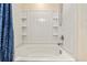 This bathroom features a white tub with shelving and a shower head at 47385 Lily Ave, Bennett, CO 80102