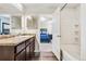This bathroom features a shower, a vanity, and a view into the bedroom at 47385 Lily Ave, Bennett, CO 80102