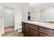 This bathroom features a shower and a vanity with dark wood cabinets at 47385 Lily Ave, Bennett, CO 80102