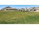View of a grassy area next to other homes and cars with an 'R' on top of one of the homes at 47385 Lily Ave, Bennett, CO 80102