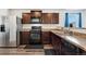 Modern kitchen featuring stainless steel appliances, brown cabinets, and stylish countertops at 47385 Lily Ave, Bennett, CO 80102