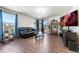 Comfortable living room with dark wood floors, black leather sofa, and backyard access at 47385 Lily Ave, Bennett, CO 80102