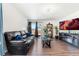Bright living room featuring stylish flooring, backyard access, and comfortable black leather sofa at 47385 Lily Ave, Bennett, CO 80102