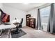 Comfortable carpeted office with dark wood bookcase, modern desk, and bright natural light at 47385 Lily Ave, Bennett, CO 80102
