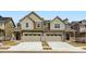 Modern townhome with beige and brown siding, a two-car garage, and a small front porch at 6751 Arbor E Blvd, Thornton, CO 80602