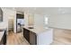 Bright kitchen with island, stainless steel appliances, quartz countertops, and hardwood floors at 6751 Arbor E Blvd, Thornton, CO 80602