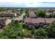 An aerial view showing neighborhood townhomes, large trees, and pond in the distance at 12783 Ivy St, Thornton, CO 80602