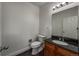 Cozy half-bath with granite countertop, a white toilet, and new vanity at 12783 Ivy St, Thornton, CO 80602