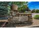 Stone community sign for Sage Creek Townhomes with a lovely flower pot on top at 12783 Ivy St, Thornton, CO 80602