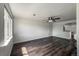 Spacious living room featuring wood-look flooring, large windows, and modern ceiling fan at 12783 Ivy St, Thornton, CO 80602