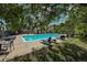 Community pool featuring lounge chairs and tables shaded by mature trees for relaxation and enjoyment at 12783 Ivy St, Thornton, CO 80602