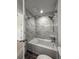 Shower and tub featuring a rainfall shower head and tile surround at 12783 Ivy St, Thornton, CO 80602