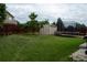Inviting backyard with green lawn, trampoline, shed, and privacy fence, perfect for outdoor enjoyment at 10534 Ursula St, Commerce City, CO 80022