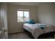Cozy bedroom with comfortable bed with blue pillows and window providing ample natural light at 10534 Ursula St, Commerce City, CO 80022