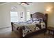 Comfortable bedroom with large wooden bed frame, ceiling fan, and plenty of natural light from two windows at 10534 Ursula St, Commerce City, CO 80022