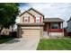 Charming home with two-car garage, covered front porch, red shutters, and a well-manicured lawn at 10534 Ursula St, Commerce City, CO 80022