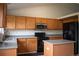 Well-lit kitchen with wood cabinets, stainless steel appliances, and a center island at 10534 Ursula St, Commerce City, CO 80022