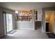 Open-concept living room with carpet, large sliding glass doors, and staircase to the basement at 10534 Ursula St, Commerce City, CO 80022