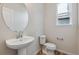 Bathroom features a pedestal sink with modern faucet, toilet, and window at 1290 Loraine N Cir, Lafayette, CO 80026