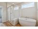 Bathroom with a glass enclosed shower and a soaking tub under a window at 1290 Loraine N Cir, Lafayette, CO 80026