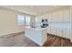 Modern kitchen featuring white cabinets, island, and hardwood floors at 1290 Loraine N Cir, Lafayette, CO 80026