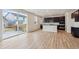 Open-concept living space featuring a modern kitchen, wood flooring, and a sliding glass door to the patio at 1290 Loraine N Cir, Lafayette, CO 80026