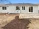 Home's backyard featuring a concrete patio, freshly turned dirt, and slider into the house at 5236 S Liverpool Way, Centennial, CO 80015