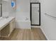 Bright bathroom featuring double sinks, tub, and glass-enclosed shower at 5236 S Liverpool Way, Centennial, CO 80015