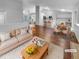Bright, open-concept living space with hardwood floors flowing to a dining area and kitchen at 5236 S Liverpool Way, Centennial, CO 80015