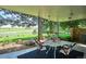 Covered patio with outdoor seating, offering views of the green lawn and mature trees at 4338 S Alton St, Greenwood Village, CO 80111