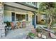 Inviting front porch with chairs and a table, surrounded by colorful flowers and decorative stone at 4338 S Alton St, Greenwood Village, CO 80111