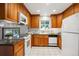Classic kitchen featuring wood cabinets, granite countertops, and modern white appliances, ideal for home cooking at 4338 S Alton St, Greenwood Village, CO 80111