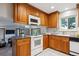 Bright kitchen with wooden cabinetry, white appliances, and tiled backsplash, offering functionality and style at 4338 S Alton St, Greenwood Village, CO 80111
