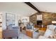 Cozy living room with a stone fireplace, hardwood floors, and comfortable seating, adjacent to the dining room at 4338 S Alton St, Greenwood Village, CO 80111