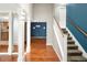 Foyer features hardwood floors, staircase, and columns leading to the kitchen at 141 S Upham Ct, Lakewood, CO 80226