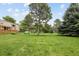 Expansive front yard featuring lush green lawn and mature trees, offering ample space for outdoor activities at 141 S Upham Ct, Lakewood, CO 80226