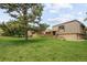 Spacious lawn with mature trees surrounding the home at 141 S Upham Ct, Lakewood, CO 80226