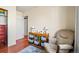 Bedroom featuring a cozy armchair, wood floors, and a wooden storage shelf with compartments at 221 Jackson Ave, Firestone, CO 80520