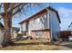 Side view of home with gray siding, brick foundation, and front yard at 221 Jackson Ave, Firestone, CO 80520